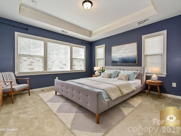 a spacious bedroom with a bed and large windows