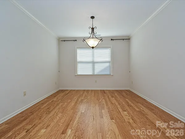 a view of empty room with wooden floor and windows