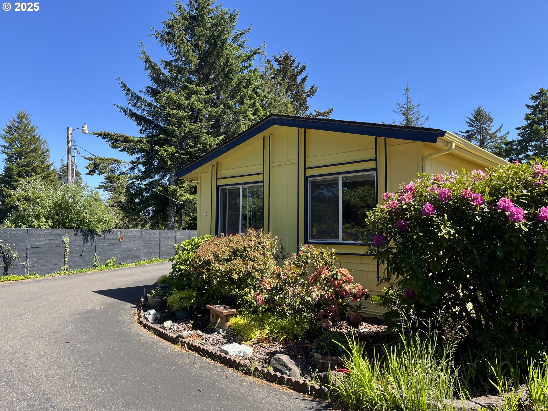 83763 Highway 101, Unit 10 Florence, OR 97439 - Photo 3 of 34 a view of a house with a yard and potted plants