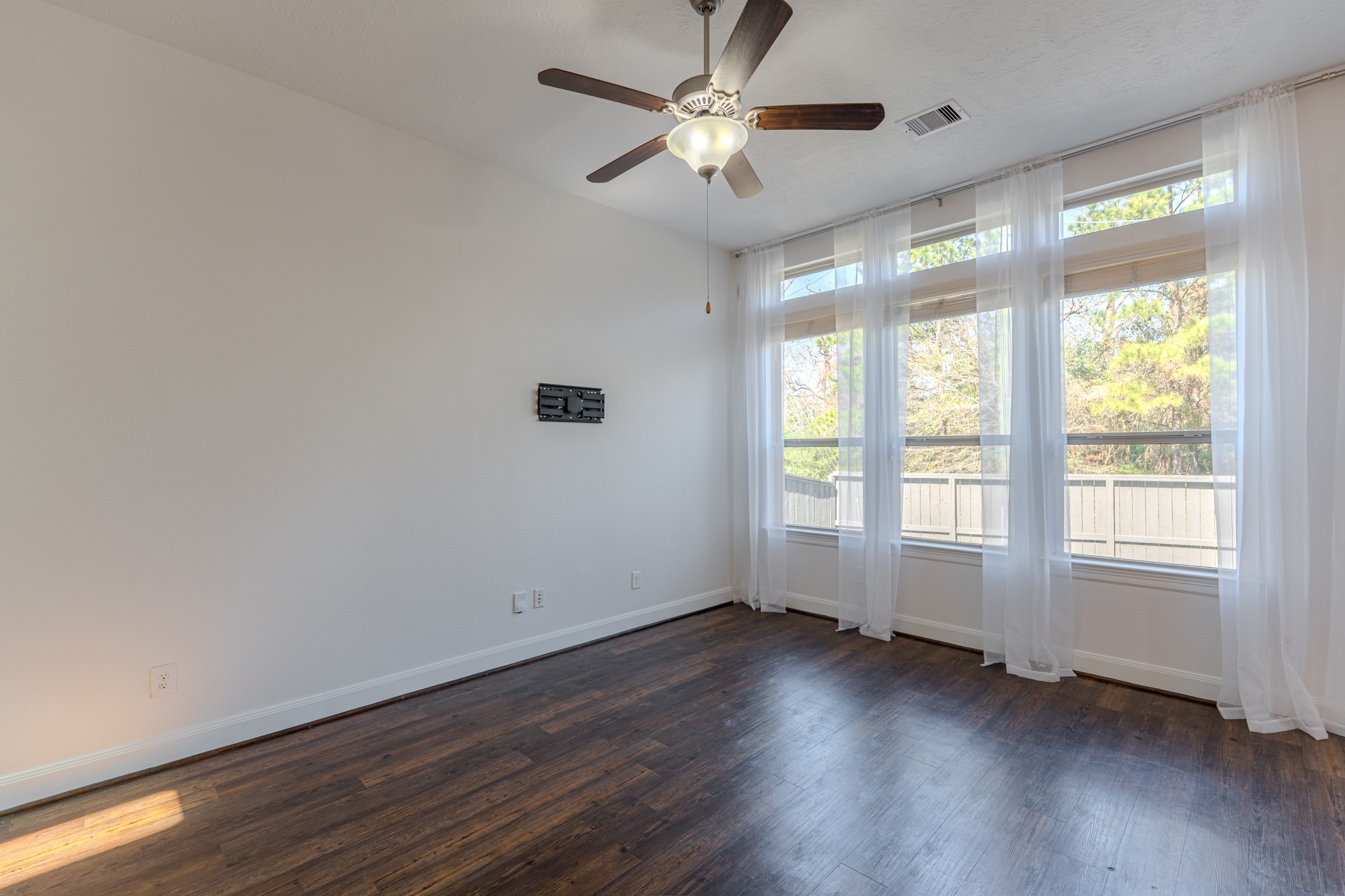58 Aventura Place Spring, TX 77389 - Photo 19 of 50 a view of an empty room with wooden floor and a window