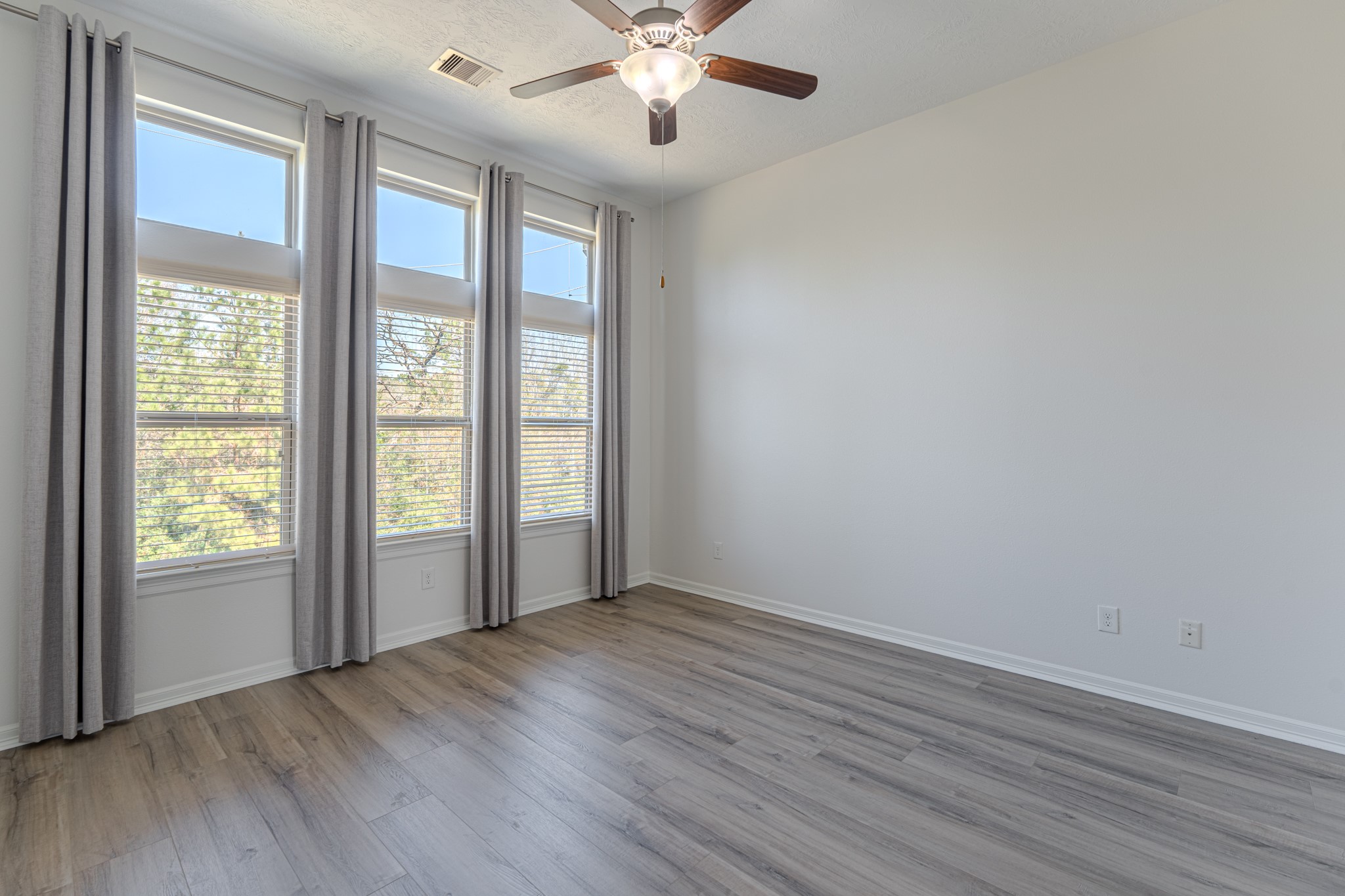 58 Aventura Place Spring, TX 77389 - Photo 32 of 50 an empty room with wooden floor fan and windows