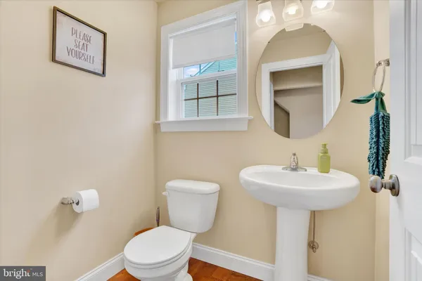 a bathroom with a toilet a sink and mirror