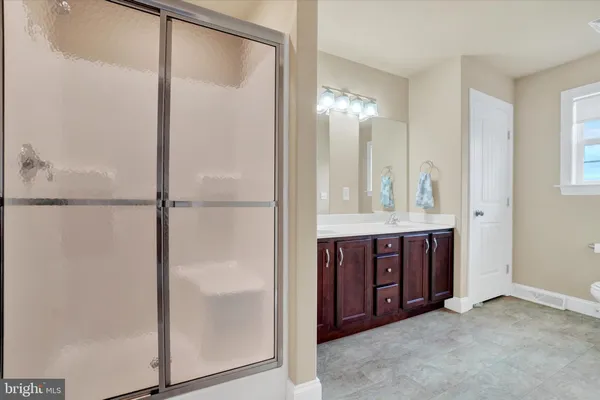 a bathroom with a glass shower door and a sink