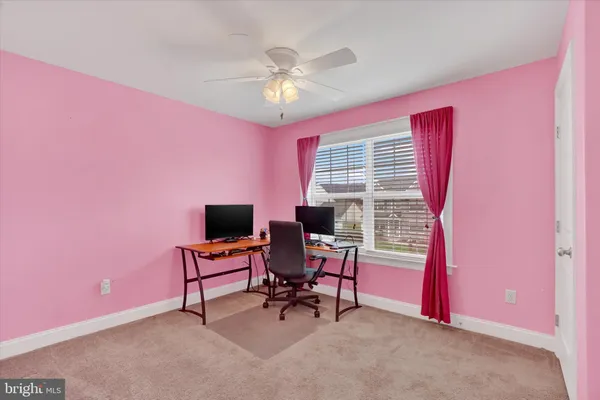 a view of a livingroom with workspace and a window