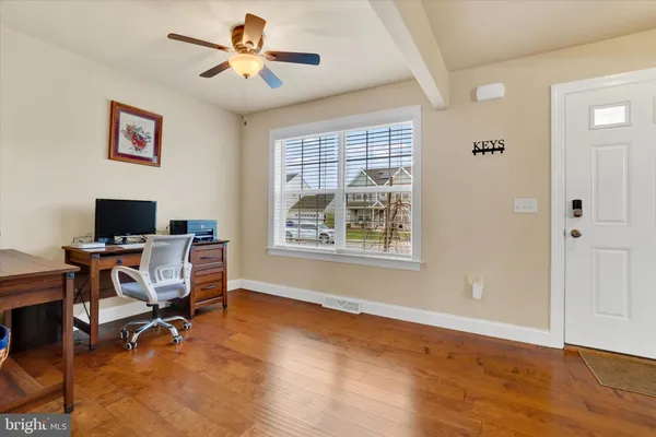 a view of a workspace with furniture and a window