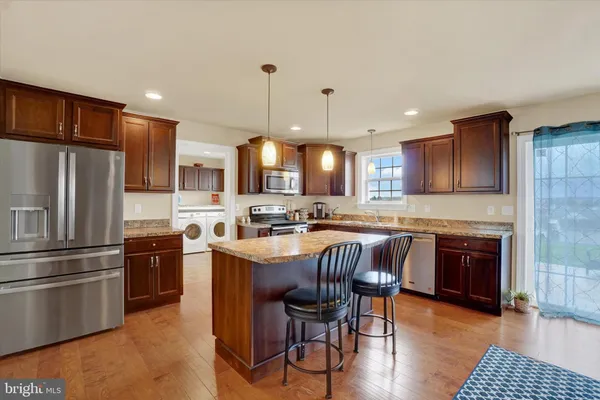 a kitchen with stainless steel appliances granite countertop a stove a sink a refrigerator and a microwave