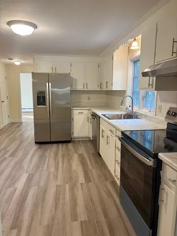 a large kitchen with stainless steel appliances granite countertop a stove a sink dishwasher and a refrigerator