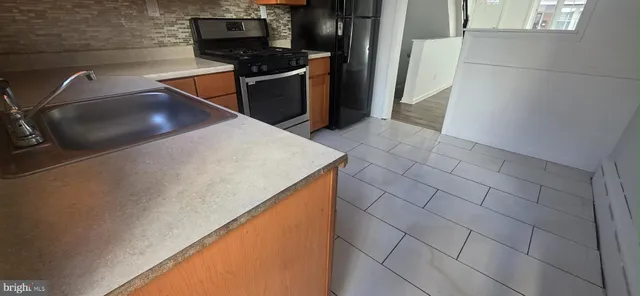 a view of a refrigerator a stove and cabinets