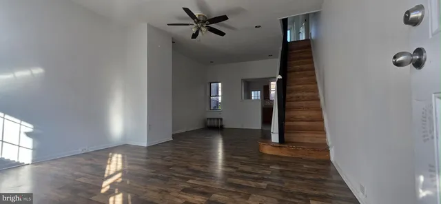 a view of a hallway with wooden floor and staircase
