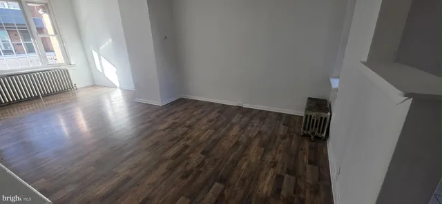 a view of a hallway with wooden floor and stairs