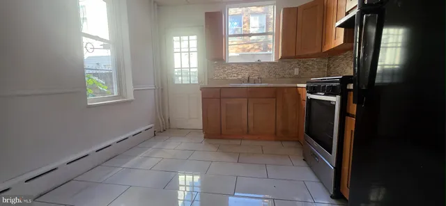 a kitchen with a sink a refrigerator and window