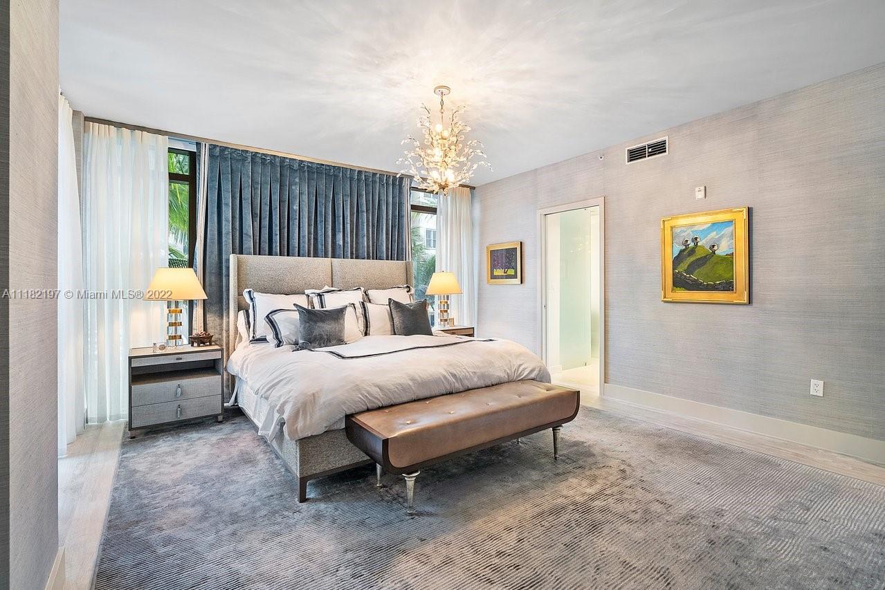 2101 South Surf Road, Unit 2C Hollywood, FL 33019 - Photo 17 of 38 a spacious bedroom with a bed and a chandelier