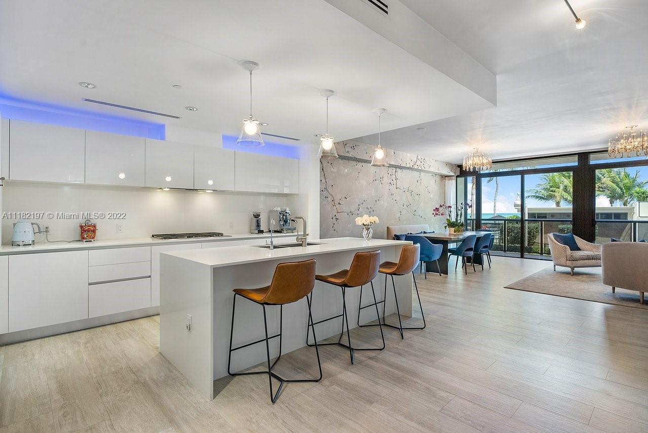2101 South Surf Road, Unit 2C Hollywood, FL 33019 - Photo 7 of 38 a kitchen with a dining table chairs and white cabinets