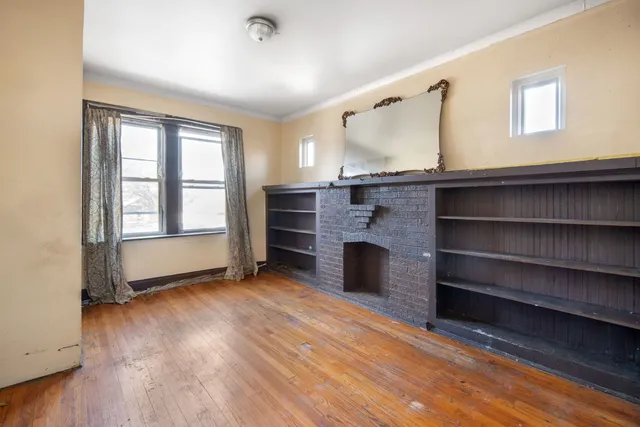 a view of an empty room with a fireplace and a window