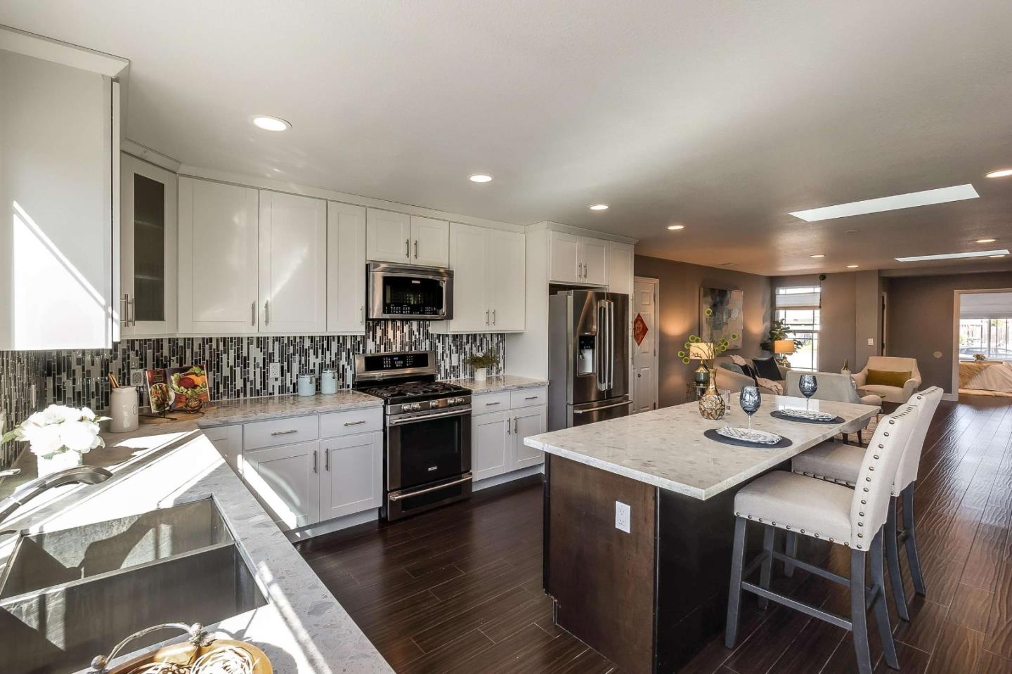36045 Haley Street Newark, CA 94560 - Photo 11 of 26 a large kitchen with sink a center island stainless steel appliances and cabinets