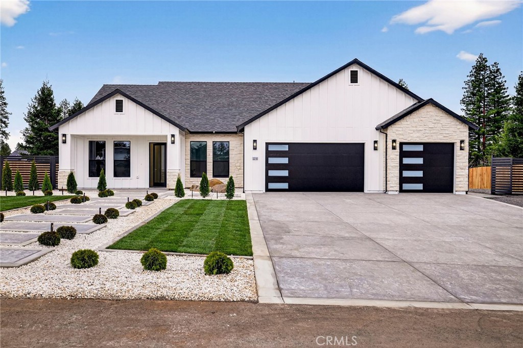 a view of a white house with a yard patio and a fire pit