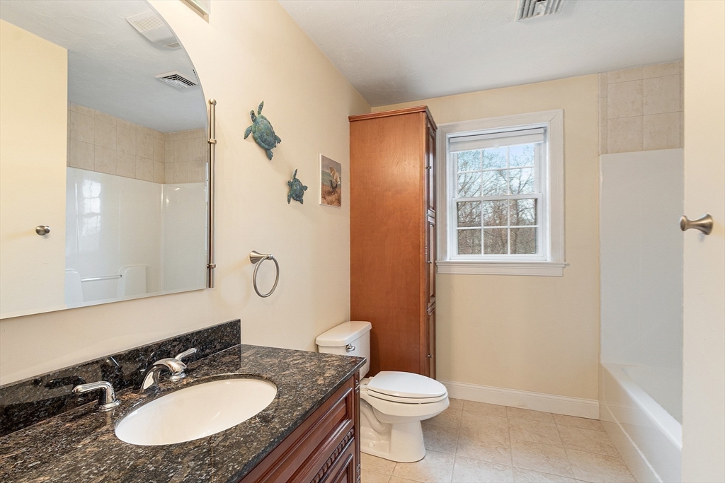 49 Brigham Hill Road Grafton, MA 01519 - Photo 21 of 37 a bathroom with a granite countertop sink a toilet a mirror and shower