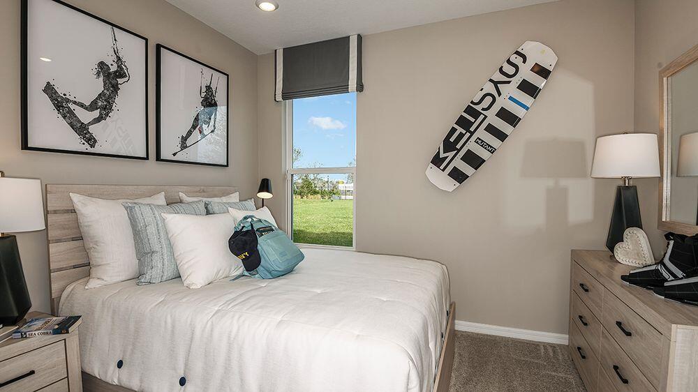 604 Southeast Ranch Oak Circle Port St. Lucie, FL 34984 - Photo 18 of 35 a bedroom with a bed and a lamp