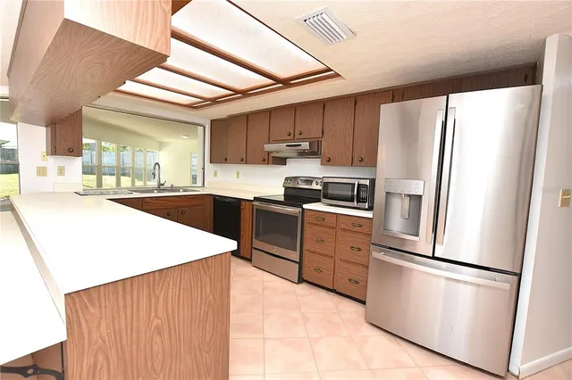 a kitchen with stainless steel appliances a refrigerator sink and cabinets