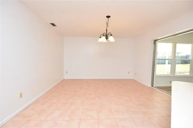 a view of a room with a hanging light and kitchen