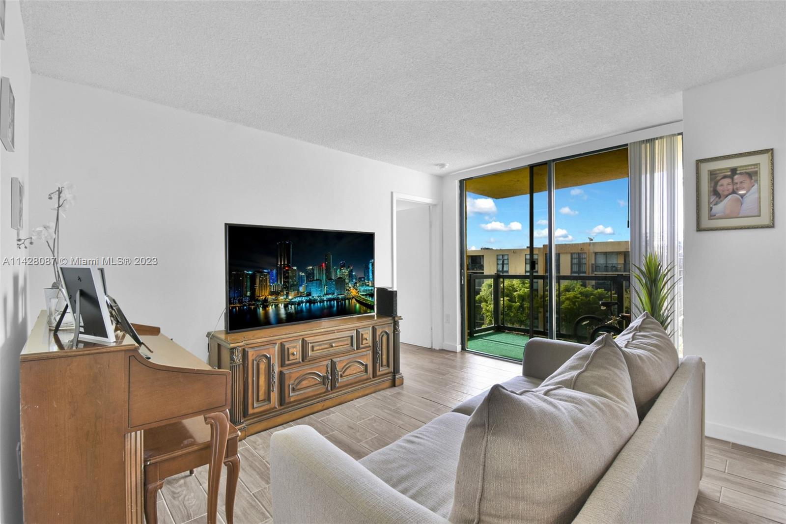 11800 Southwest 18th Street, Unit 5084 Miami, FL 33175 - Photo 14 of 44 a living room with furniture a flat screen tv and a floor to ceiling window