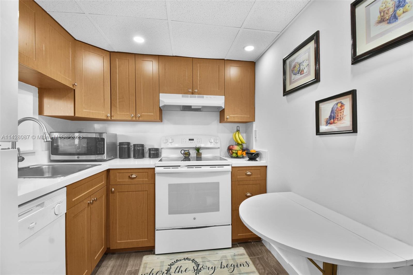 11800 Southwest 18th Street, Unit 5084 Miami, FL 33175 - Photo 10 of 44 a kitchen with a sink a stove cabinets and wooden floor