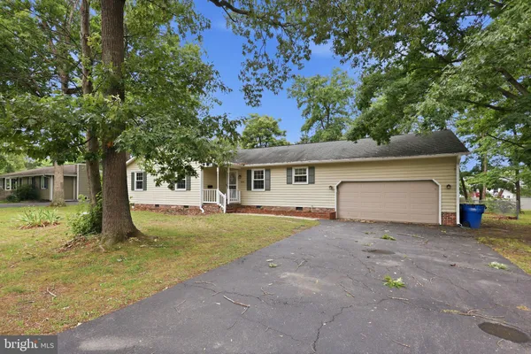 a view of a house with backyard and a tree