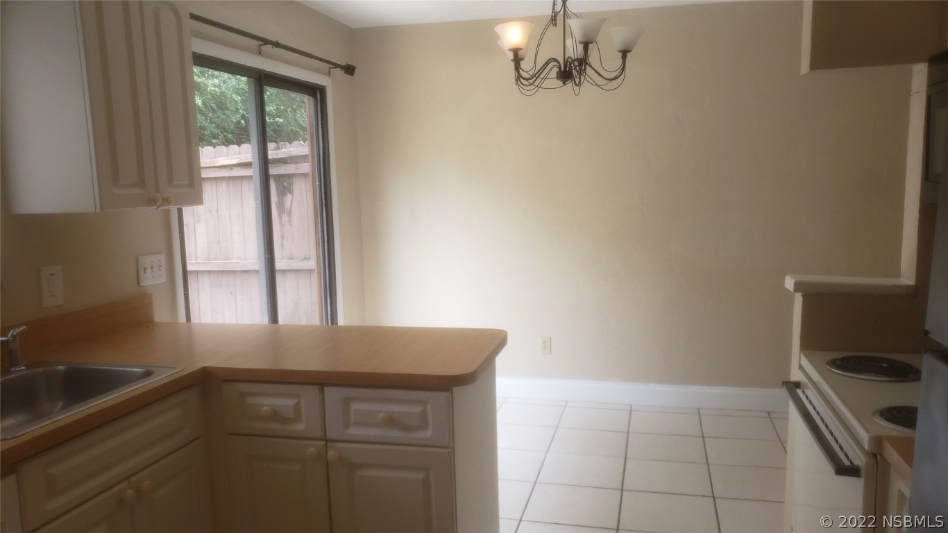 322 Canal Road, Unit 22 Edgewater, FL 32132 - Photo 11 of 17 a kitchen with a window a sink and a stove