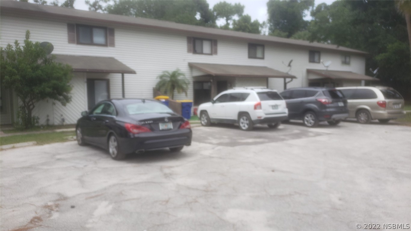 322 Canal Road, Unit 22 Edgewater, FL 32132 - Photo 2 of 17 a car parked in front of white house