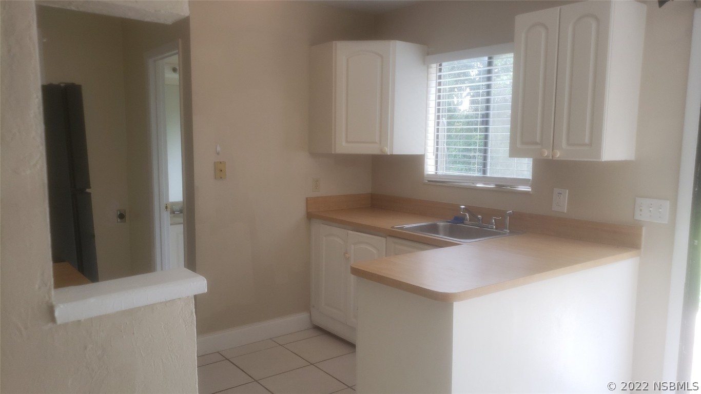 322 Canal Road, Unit 22 Edgewater, FL 32132 - Photo 6 of 17 a kitchen with a sink cabinets and a window