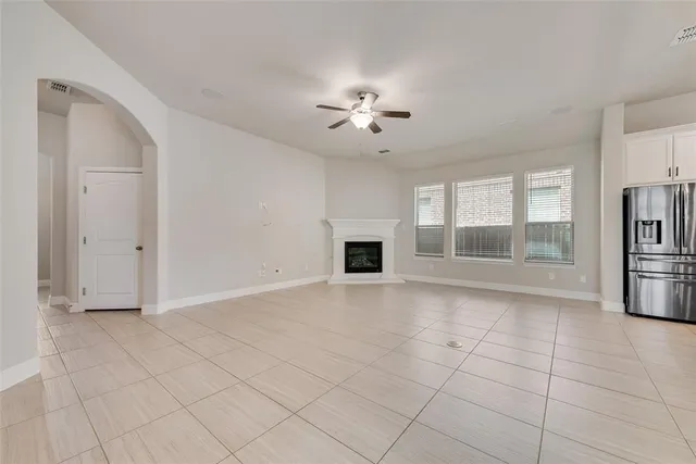 a view of an empty room with a fireplace and a window