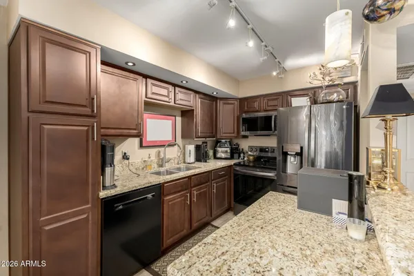 a kitchen with granite countertop stainless steel appliances and refrigerator
