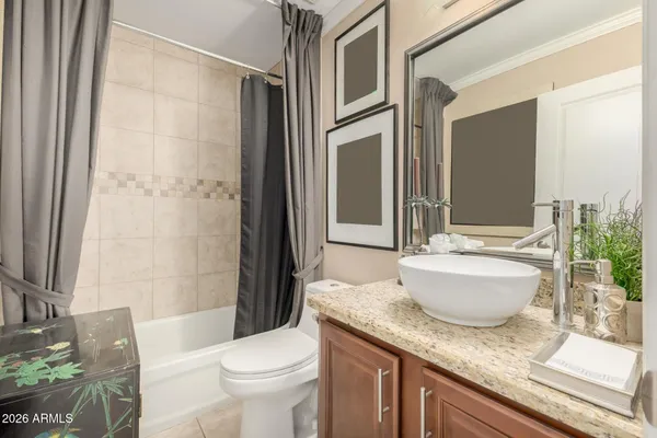 a bath room with a granite countertop toilet a sink and a mirror