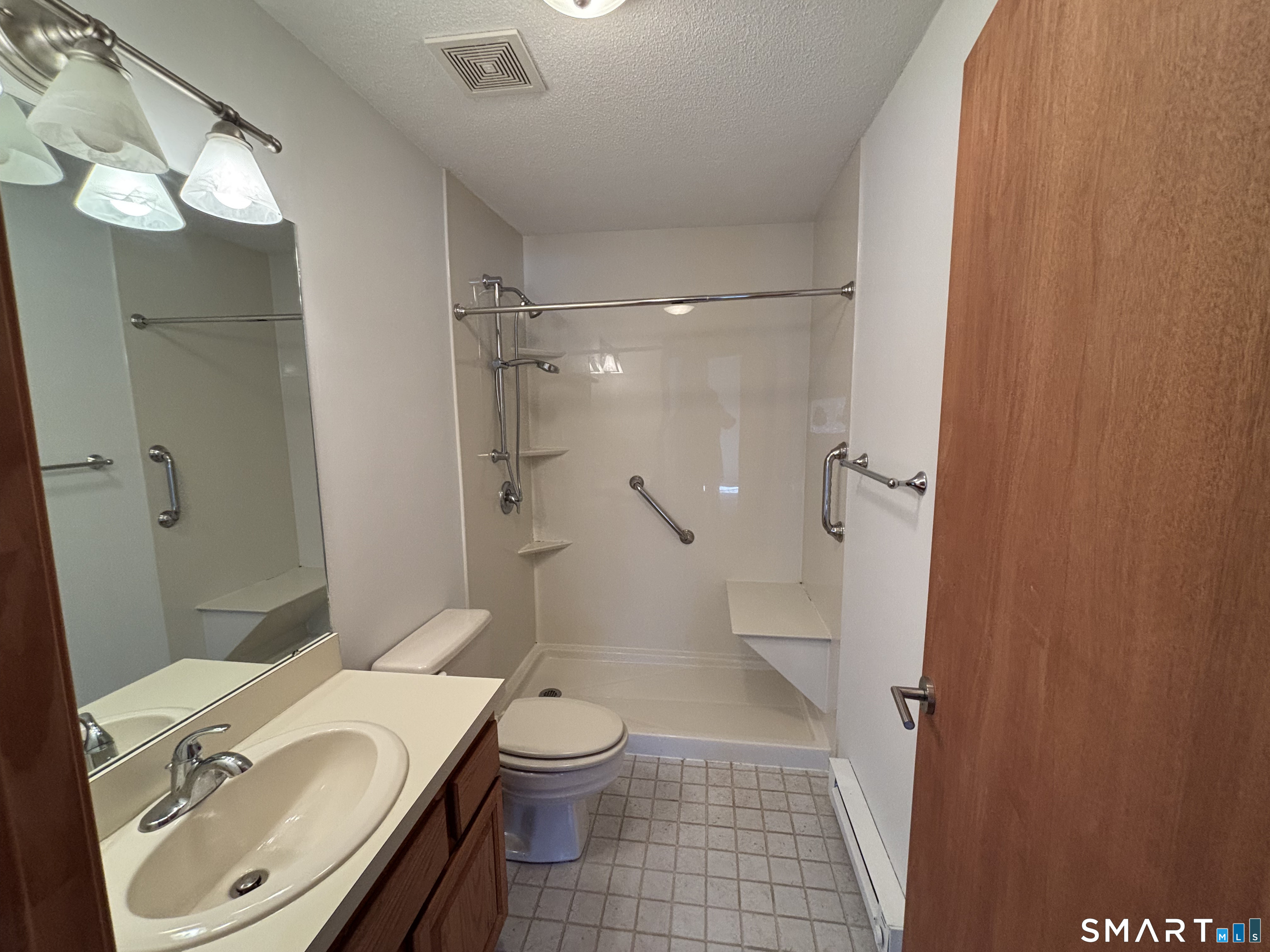 16 Putter Drive, Unit 207S Wallingford, CT 06492 - Photo 12 of 15 a bathroom with a granite countertop sink toilet and shower