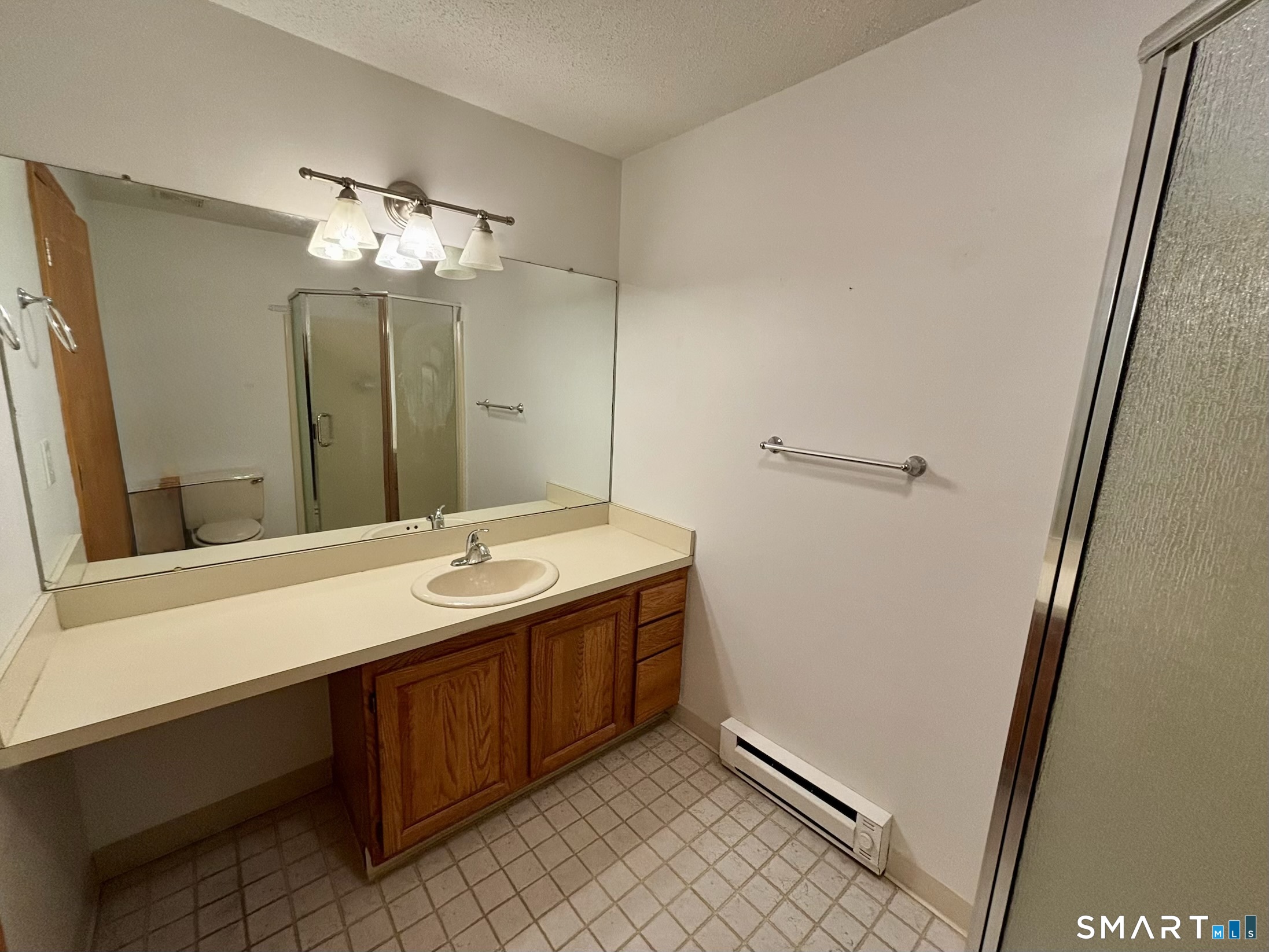 16 Putter Drive, Unit 207S Wallingford, CT 06492 - Photo 9 of 15 a bathroom with a sink a mirror and a shower