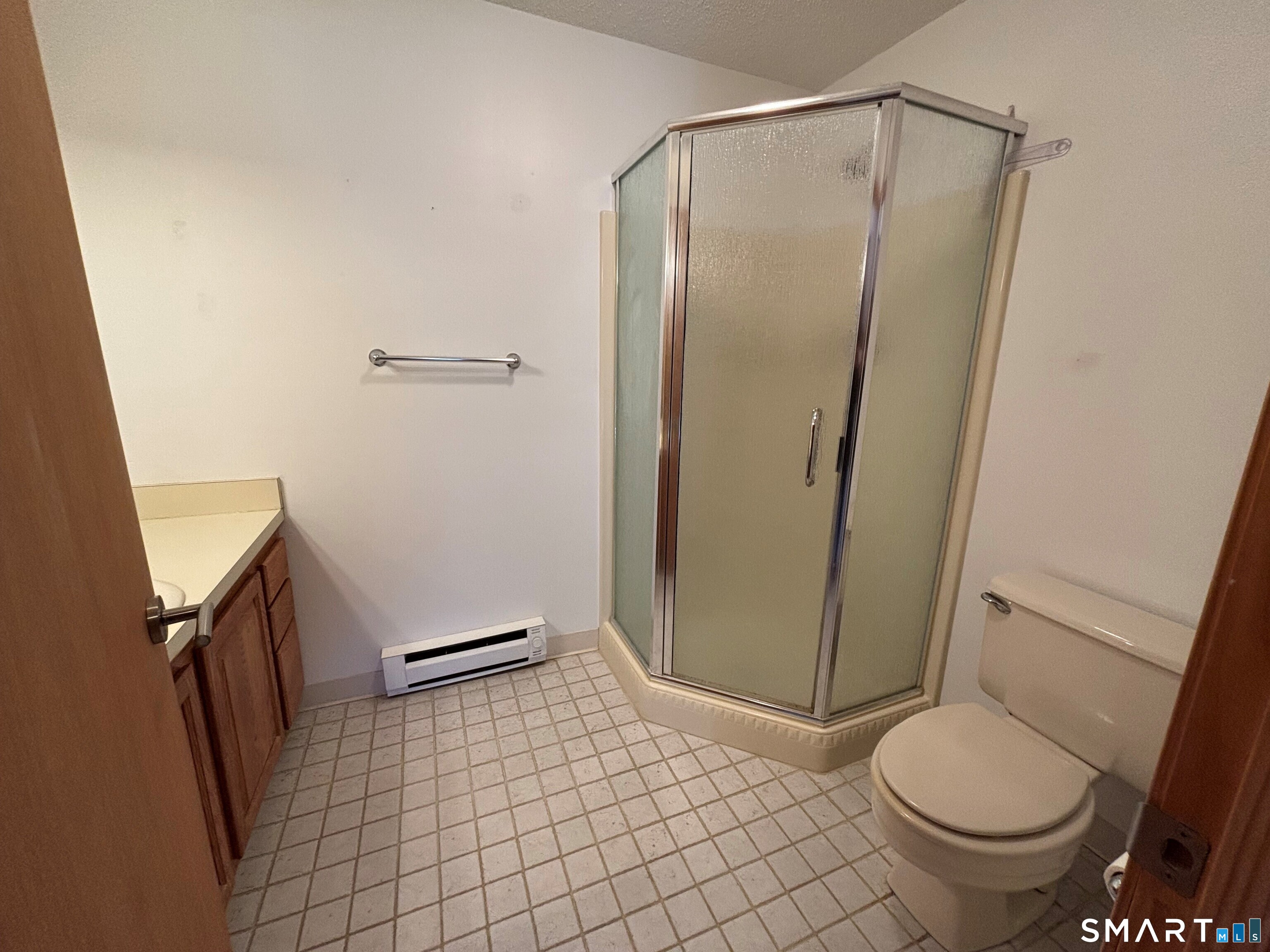 16 Putter Drive, Unit 207S Wallingford, CT 06492 - Photo 10 of 15 a bathroom with a granite countertop toilet and a mirror