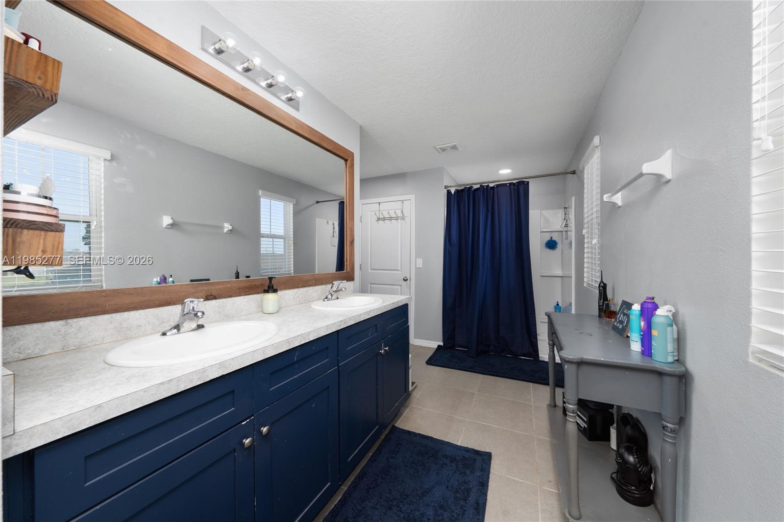 2824 Northeast 43rd Road Ocala, FL 34470 - Photo 18 of 45 a bathroom with a sink vanity and a mirror