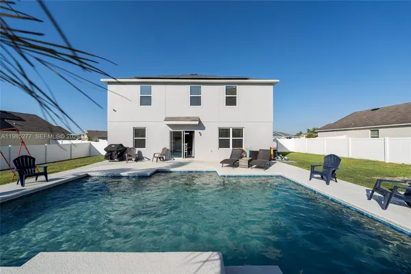 a backyard of a house with table and chairs