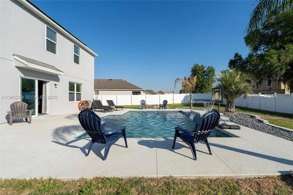 a view of a backyard with a patio and swimming pool