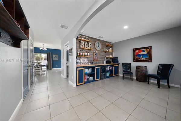 a living room with lots of furniture and a refrigerator