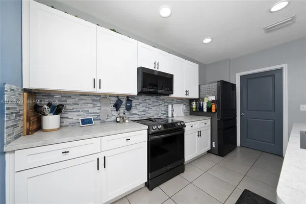 a kitchen with stainless steel appliances granite countertop a refrigerator and a stove top oven