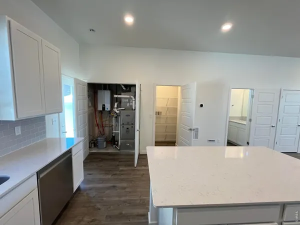 a large white kitchen with kitchen island a sink stainless steel appliances and cabinets