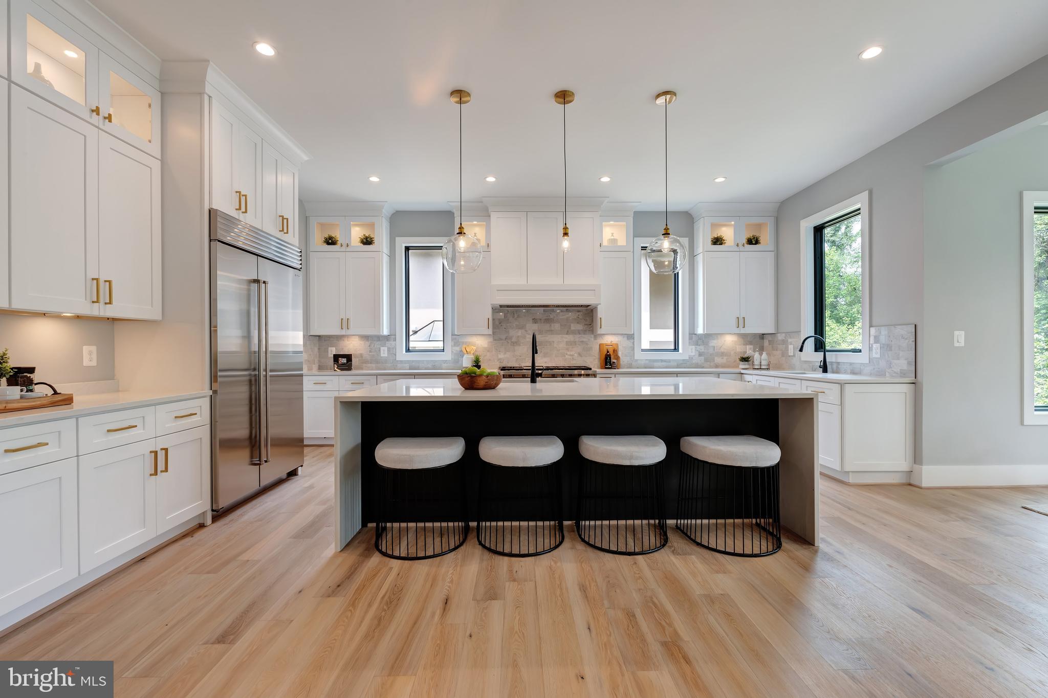 6800 Old Chesterbrook Road McLean, VA 22101 - Photo 15 of 44 a kitchen with a sink dishwasher a stove a dining table and chairs with wooden floor