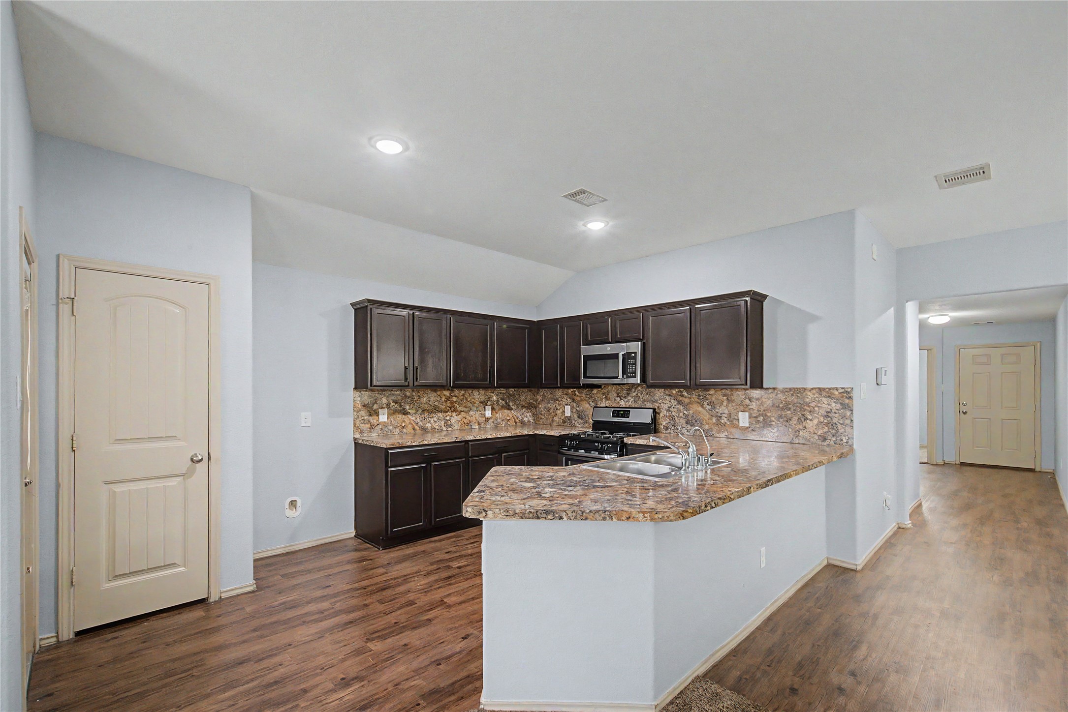 16430 Rodeo River Road Houston, TX 77049 - Photo 22 of 34 a large kitchen with stainless steel appliances granite countertop a stove a sink and a refrigerator