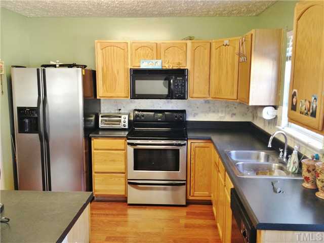 4113 Palafox Court Raleigh, NC 27604 - Photo 11 of 25 a kitchen with stainless steel appliances a stove a sink and a microwave