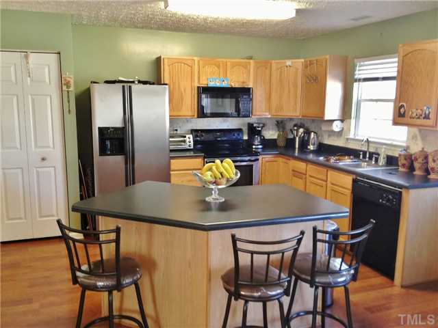 4113 Palafox Court Raleigh, NC 27604 - Photo 12 of 25 a kitchen with a table chairs refrigerator and microwave