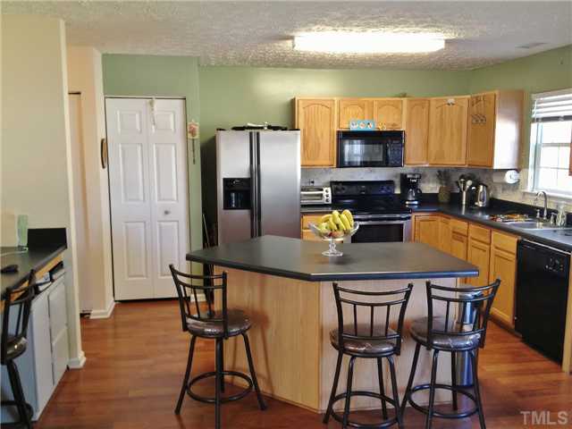 4113 Palafox Court Raleigh, NC 27604 - Photo 9 of 25 a kitchen with stainless steel appliances wooden floor dining table and chairs