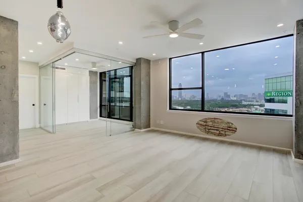 an open space with large windows and chandelier