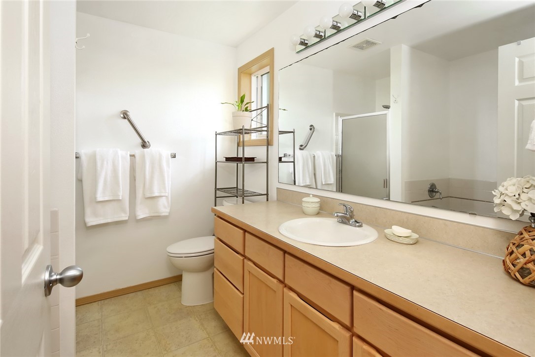 7503 Seashell Way Blaine, WA 98230 - Photo 21 of 31 a bathroom with a granite countertop sink a toilet a mirror and shower