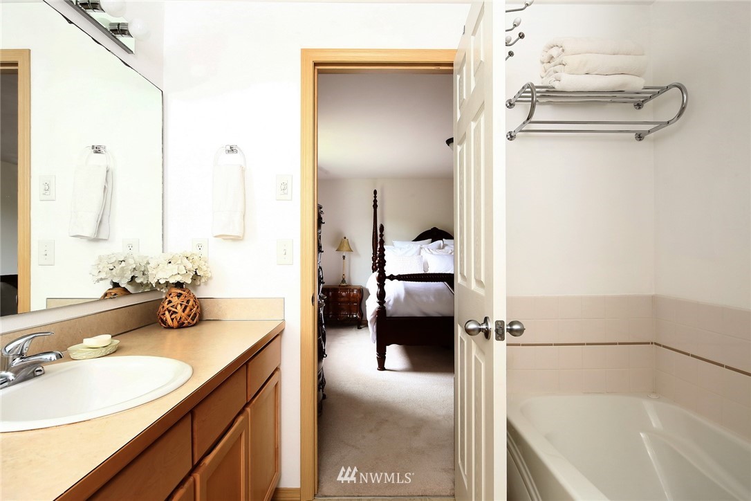 7503 Seashell Way Blaine, WA 98230 - Photo 22 of 31 a en suite bathroom with a granite countertop sink and a mirror